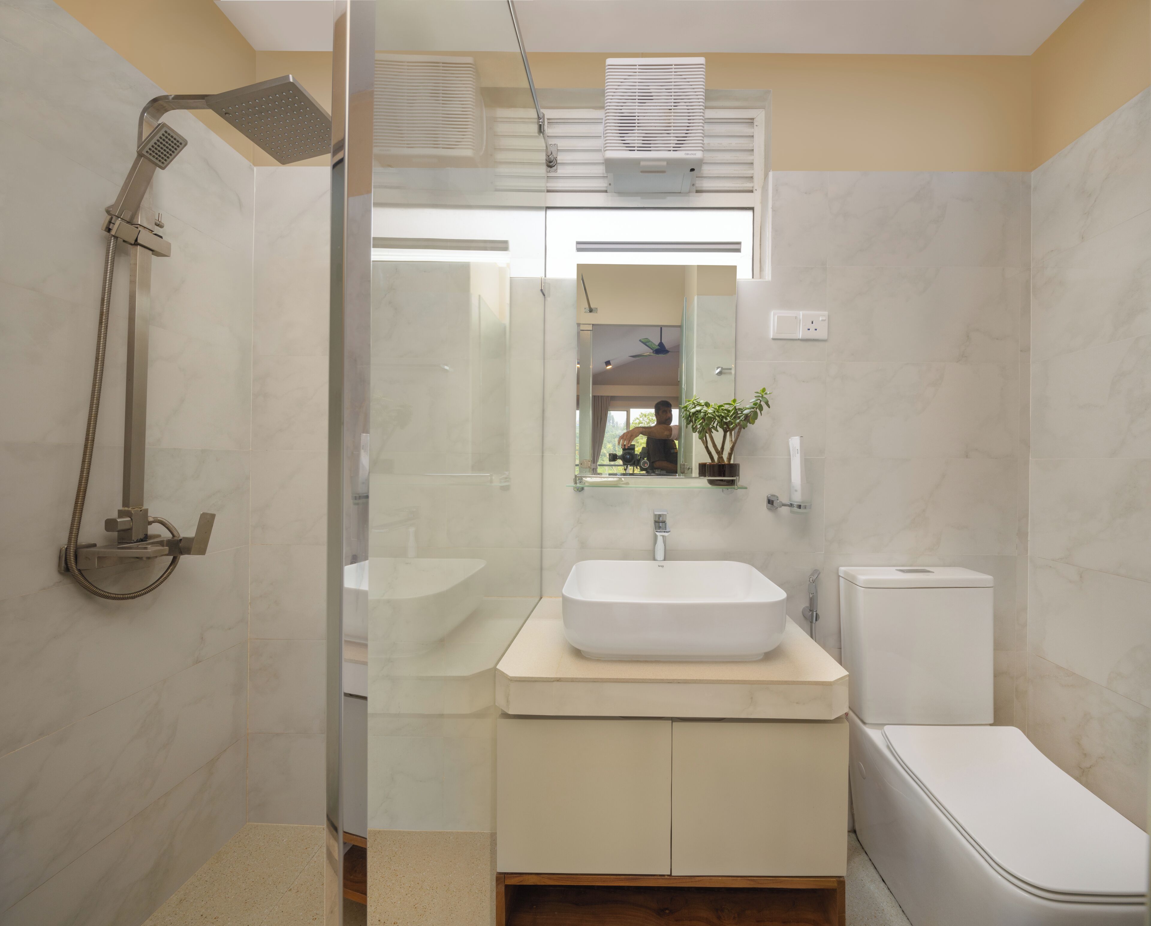 Une salle de bain moderne avec une douche à parois de verre, un lavabo blanc et des toilettes.