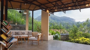 A modern living room with a wooden ceiling, large windows, a sofa, a coffee table, and a bookshelf. - The Cubes Ella  (Ella)