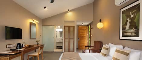 A modern hotel room with a bed, desk, chair, and a television.