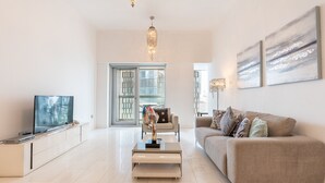 Ein modernes Wohnzimmer mit Flachbildfernseher, Couch, Couchtisch und einer Deckenleuchte.