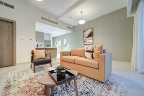 Un salon moderne avec un canapé beige, une chaise en bois et une table basse.