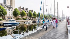 Un port de plaisance avec des bateaux amarrés, une promenade en bois et des bâtiments en arrière-plan.