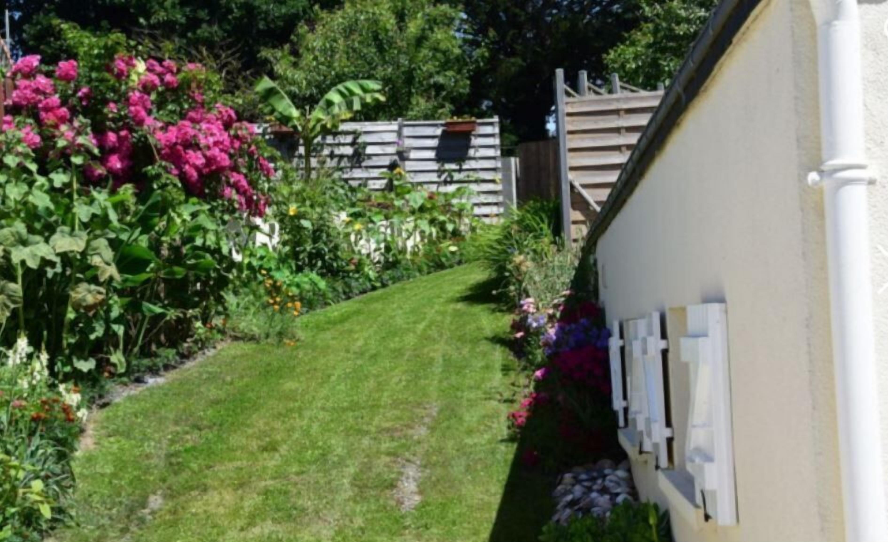 A well-maintained garden with a variety of flowers and a neatly trimmed lawn.