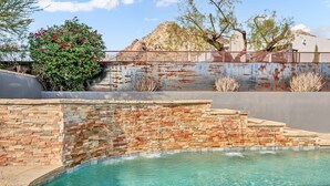 A swimming pool with a brick wall and a metal fence in the background. - The Desert Trailhead Retreat Phoenix with Pool (Phoenix)