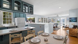 A spacious kitchen with a dining area, wooden cabinets, and a view of the outdoors. - Spacious Family Beach Getaway | Scenic Bay Views, AC and Parking! (San Diego)