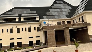 A building with a flat roof, multiple windows, and a brick entrance. - Ibom Waterfall Resorts and Suites (Arochukwu)