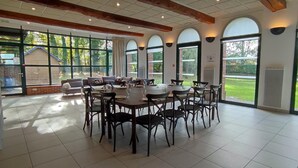 Comedor con mesa redonda, sillas y ventanas amplias con vistas al exterior.