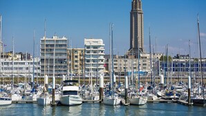 A marina with numerous boats docked, surrounded by multi-story buildings.
