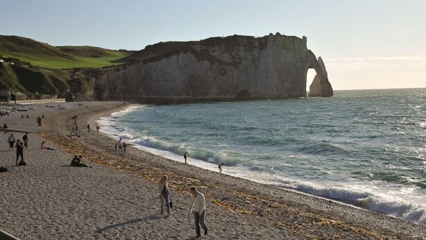 A beach with a prominent cliff formation.