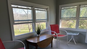 A room with a wooden table, two red chairs, a small white table, and a potted plant. - Calla Lily #2 - Oneonta Apartment close to downtown - 1 of 2 units (Oneonta)