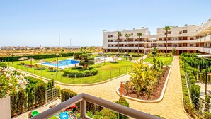 Un resort con piscina, palmeras y vista al mar.