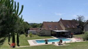 A stone house with a swimming pool, a covered patio, and a garden. - Longère *** with large heated swimming pool, sports room, billiards table, fibreglass in the countryside (La Roche-l'Abeille)