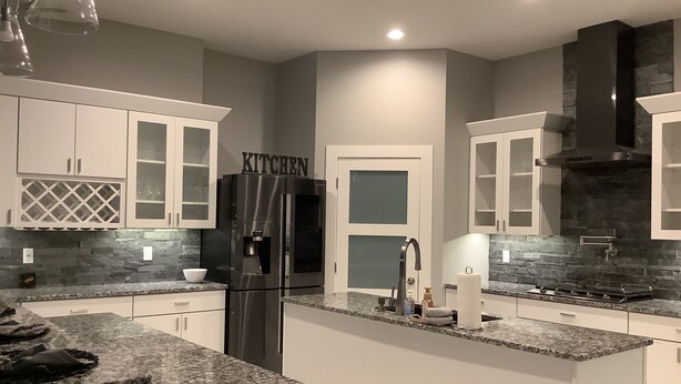 A modern kitchen with granite countertops, stainless steel appliances, and a stone backsplash. - Modern comfort, small town charm. Room for 
all to visit, rest retreat or create (Center Point)