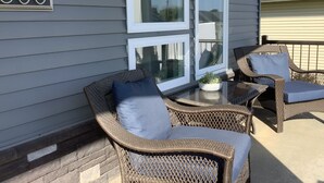 A patio with wicker furniture, a small table, and a potted plant. - Modern comfort, small town charm. Room for 
all to visit, rest retreat or create (Center Point)