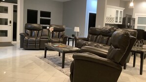 A modern living room with leather sofas, a coffee table, and a TV. - Modern comfort, small town charm. Room for 
all to visit, rest retreat or create (Center Point)