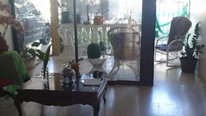 Quarto com um lustre, uma porta de vidro que dá para o exterior e uma mesa com cadeiras.