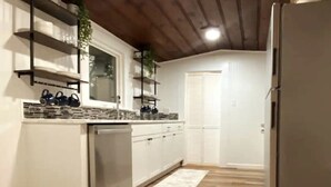A kitchen with white cabinets, a built-in oven, and a refrigerator.