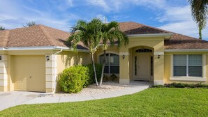 A residential house with a garage, a front door, and a small lawn.