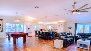 A spacious living room with a pool table, a dining area with chairs, a sofa, and a ceiling fan. - 30% Disc-2 Kg Mstrs, Golf, Fishing, BBQ, Pool, Spa (Cape Coral)