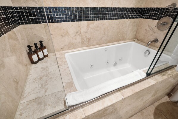 A modern bathroom with a freestanding bathtub, a glass shower enclosure, and a tiled backsplash. - Bayfront Paradise - Gorgeous Views, Garage, Massive Rooftop Deck & AC - Dogs Welcome! (San Diego)