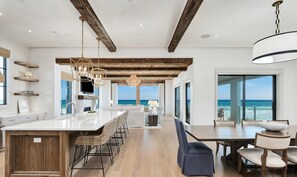 A spacious kitchen with a large island, wooden beams, and a view of the ocean. - ✨ Seawalk Sanctuary | Private Beach Access | Rooftop Pool & 30A Views | FREE Chair Service (Santa Rosa Beach)