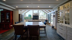 A modern kitchen with a large island, dark tiled flooring, and white cabinetry. - Very Private Rustic Home, sleeps 14, Huge Yard (Langley Township)