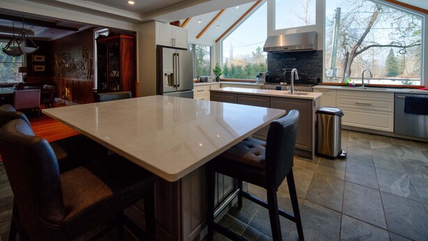 A modern kitchen with a large island, stainless steel appliances, and a view of the outdoors. - Very Private Rustic Home, sleeps 14, Huge Yard (Langley Township)