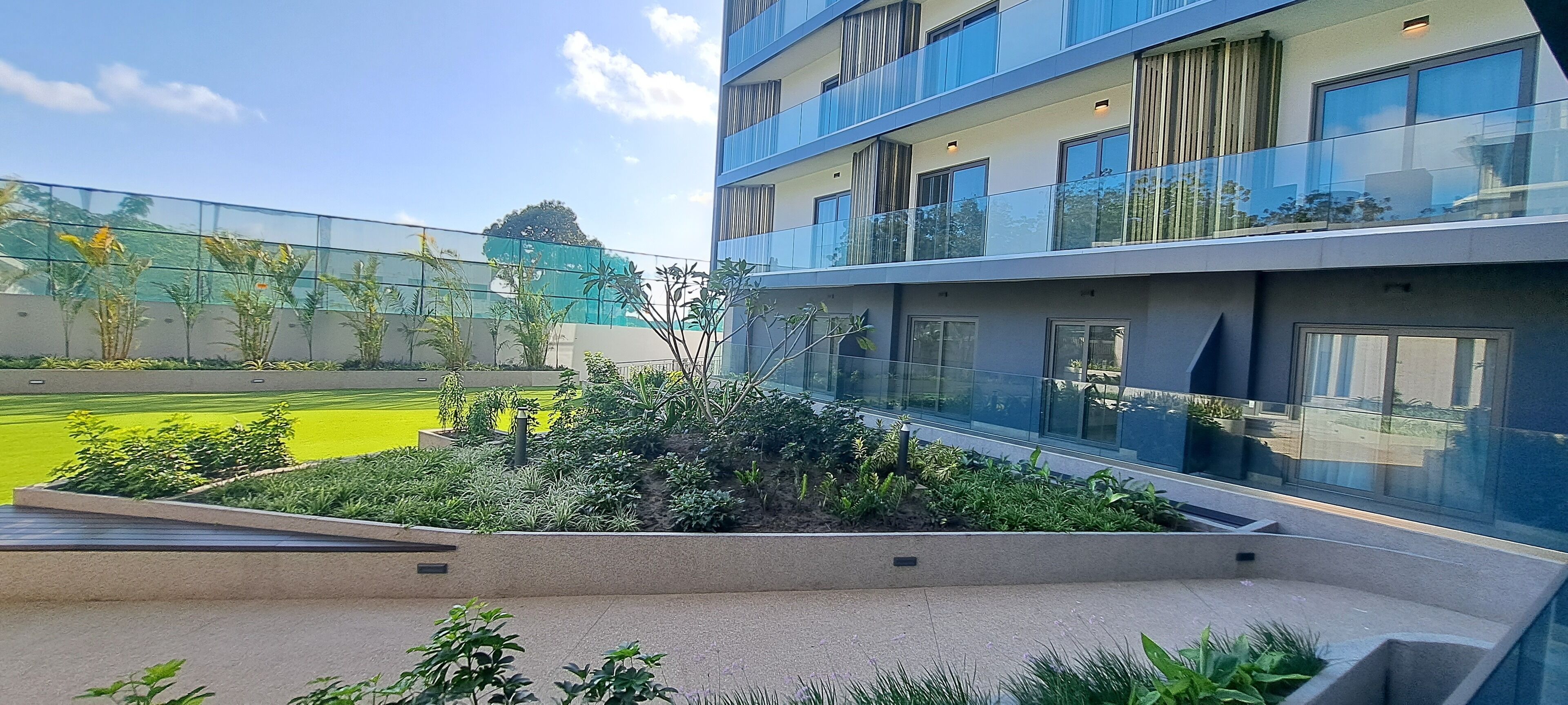 A modern building with multiple balconies and a rooftop garden.