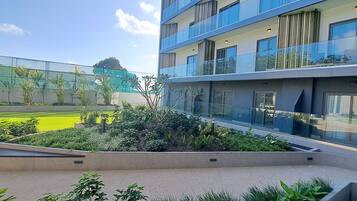 Un bâtiment moderne doté de nombreux balcons et d’un jardin sur le toit.