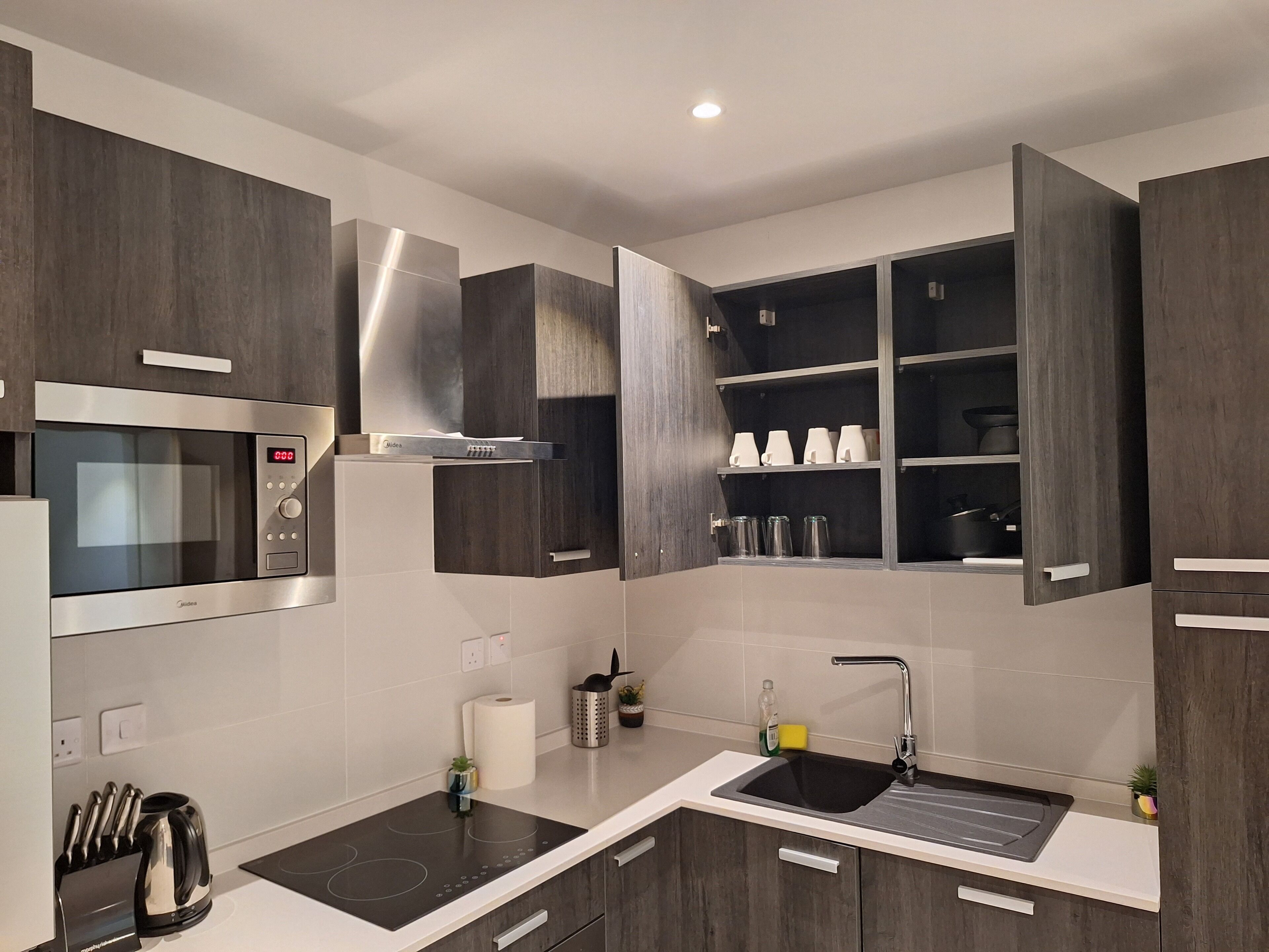 A modern kitchen with a built-in microwave, stove, and sink.