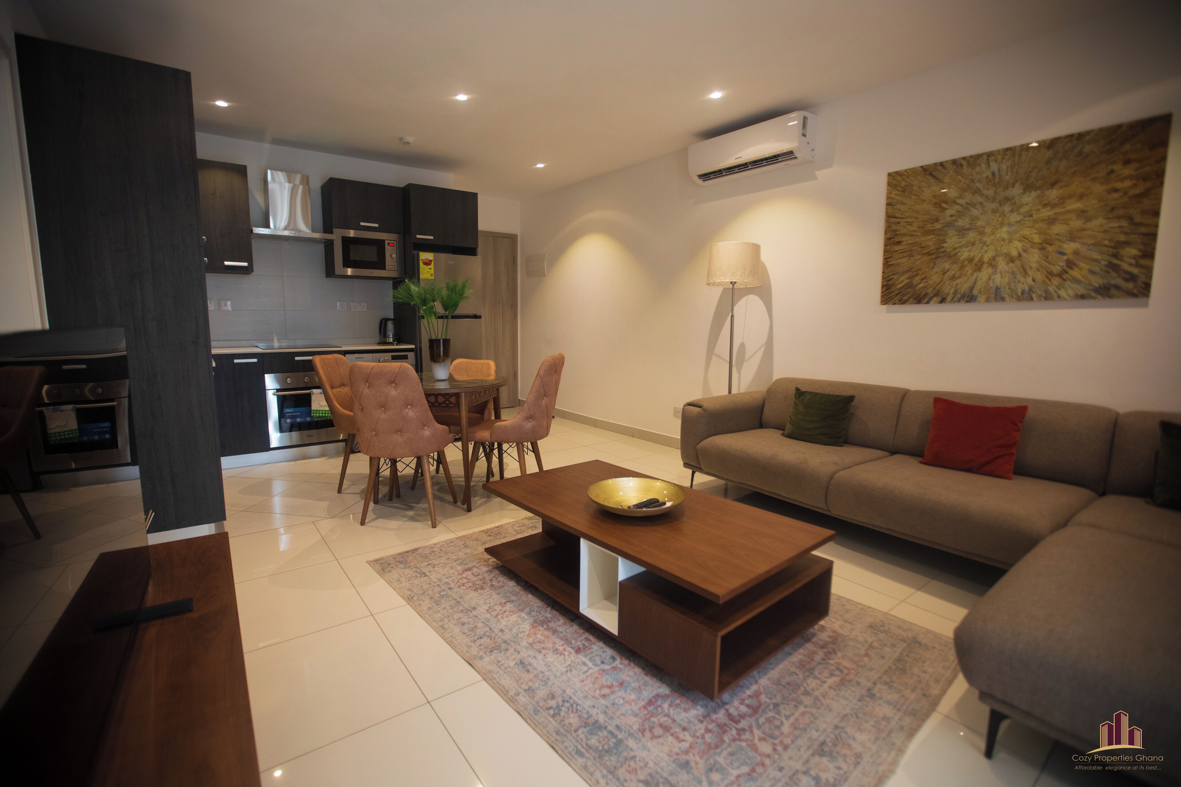 A modern living room with a sofa, coffee table, and dining area.
