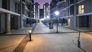 Een moderne stadsweg in de schemering met verlichte lantaarns en gebouwen.