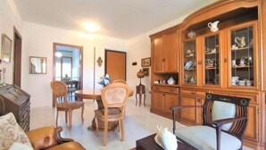 A living room with a dining area, wooden cabinets, and a fireplace. - Casa Maccianti by Interhome (Follonica)