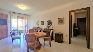 A dining area with a round table and four chairs, a small cabinet, and a framed picture on the wall. - Casa Maccianti by Interhome (Follonica)