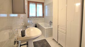 Et moderne badeværelse med badekar, vask og toilet.