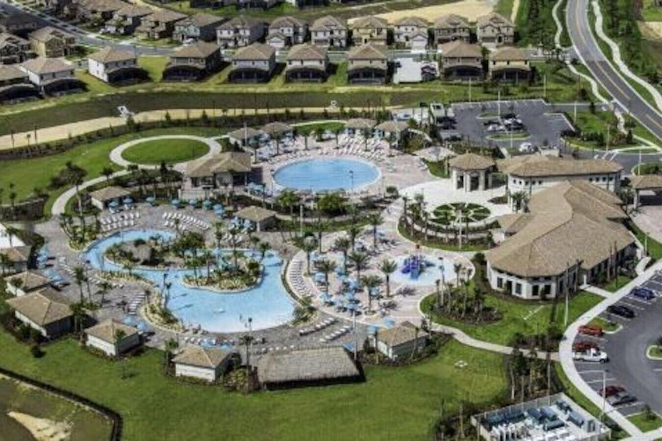 A resort with multiple swimming pools, a central courtyard, and a variety of buildings.