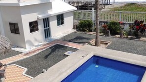 A rectangular swimming pool with a concrete edge and a metal ladder on one side. - Cabañas Vistamar  (Crucita)