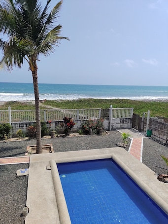 Una piscina al aire libre, sillones reclinables de piscina