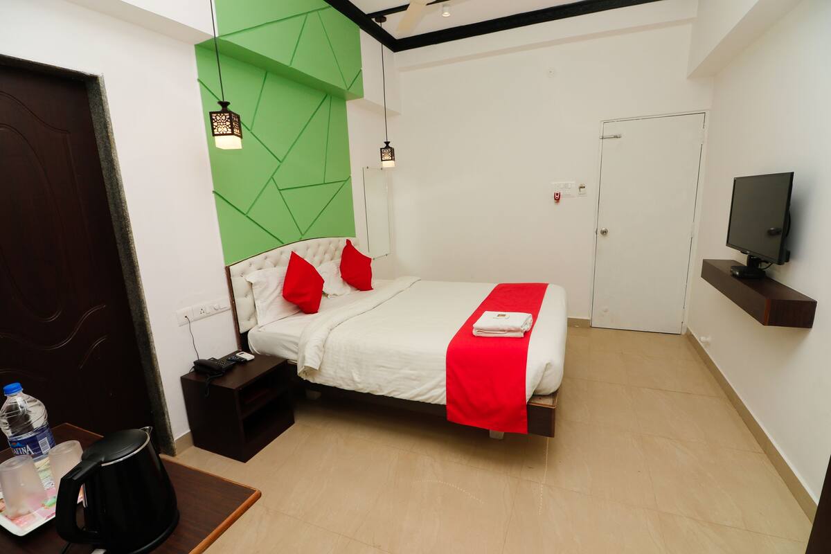 A modern hotel room with a bed, bedside table, and a TV.