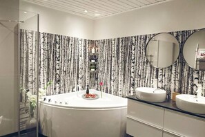 Een aparte badkuip en douche, een diep bad, handdoeken