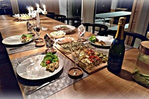 Enjoy a warm and inviting dining experience with a beautifully set table, complete with a variety of dishes and fine wine.