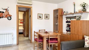 A compact living space with a dining table, two chairs, a sofa, a cabinet, and a wall-mounted heater. - CENTRIC APARTMENT with POOL in TOSSA 2 (Tossa de Mar)