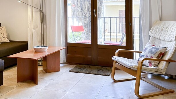 A living room with a sofa, a wooden coffee table, a rocking chair, and a floor lamp. - CENTRIC APARTMENT with POOL in TOSSA 2 (Tossa de Mar)