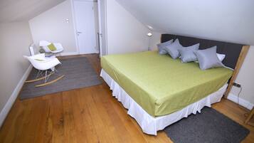 A bedroom with a bed, a rocking chair, and a desk.