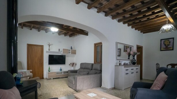A living room with a TV, sofa, and a wooden coffee table. - Casa Rural Dehesa de Algar (Algar)