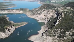 An aerial view of a coastal landscape with a large body of water, rocky terrain, and sparse vegetation. - Casa Rural Dehesa de Algar (Algar)