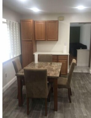 Cozy dining area with a table and four chairs, featuring cabinetry and a countertop.