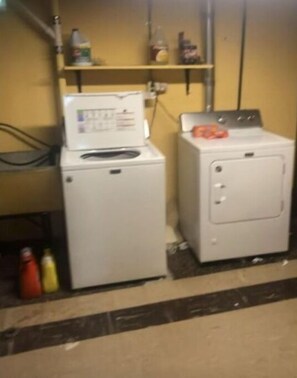 Convenient laundry facilities feature two washing machines and a storage shelf.