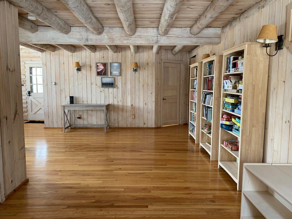 Un interno in legno con pavimento in legno, una scrivania e scaffali.