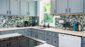 A kitchen with light blue cabinets, a large window, and a backsplash with blue and white tiles. - Spacious Getaway 15 mins from Downtown Atlanta (Decatur)